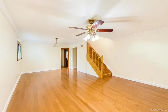 a view of a hallway with wooden floor and staircase