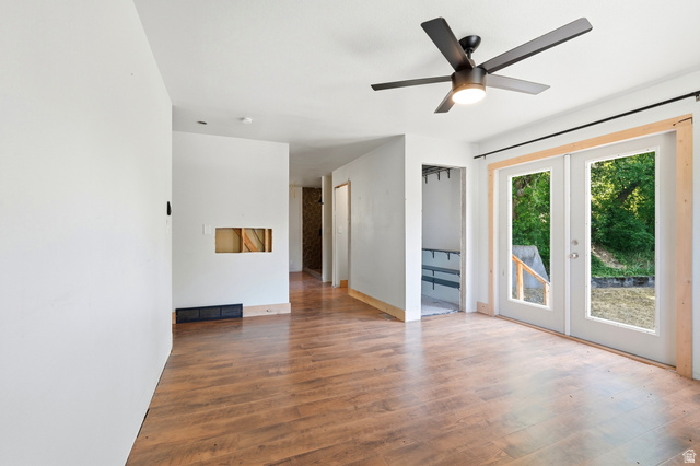 1410 Sumac Drive Logan, UT 84321 - Photo 13 of 28 Spacious room featuring wood-finish flooring, a contemporary ceiling fan with integrated lighting, and white walls