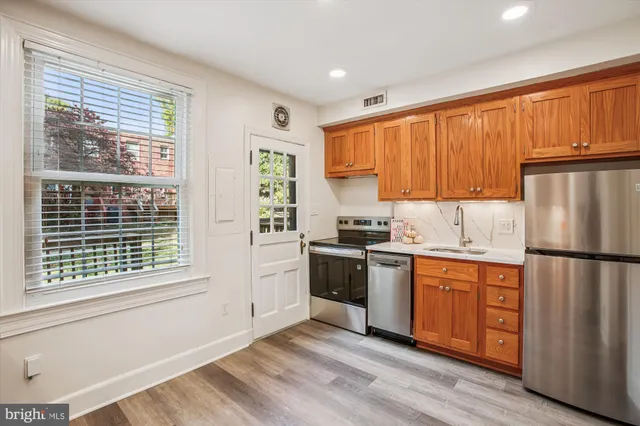 a kitchen with stainless steel appliances granite countertop a sink stove and cabinets