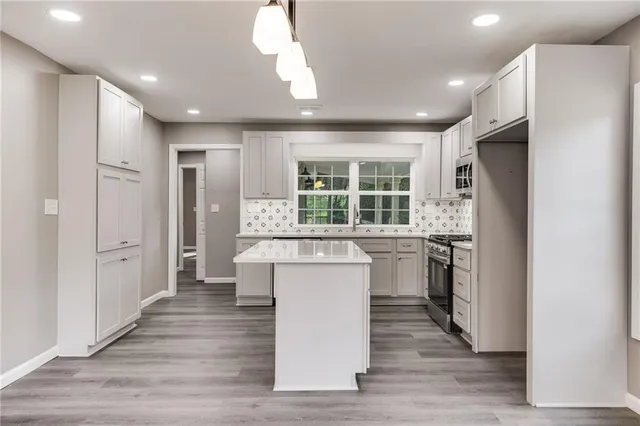 a kitchen with a refrigerator and a stove top oven