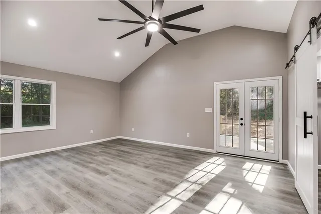 en empty room with windows and ceiling fan