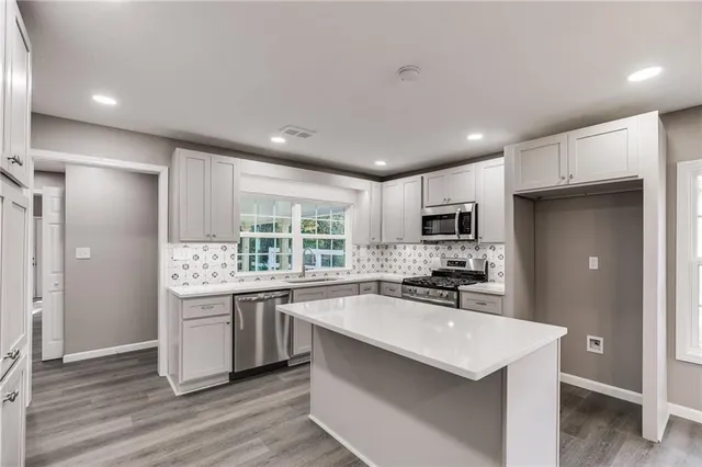 a kitchen with stainless steel appliances a sink stove and refrigerator