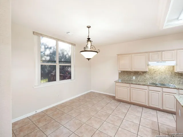 a bathroom with a granite countertop sink and a window