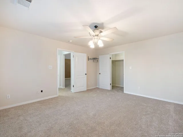 an empty room with a ceiling fan and a window