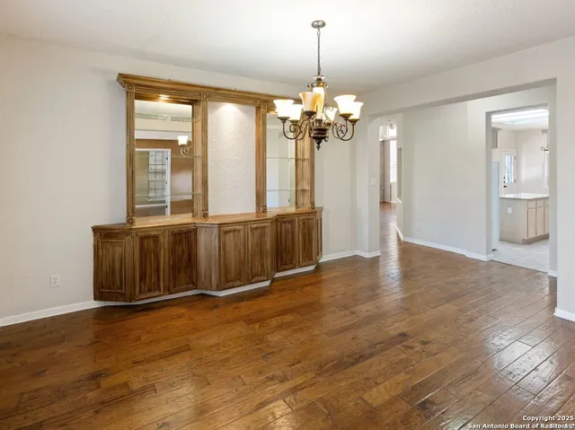 a view of a livingroom with a furniture wooden floor and chandelier