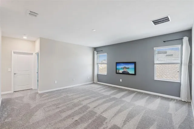 a view of an empty room with window and stairs