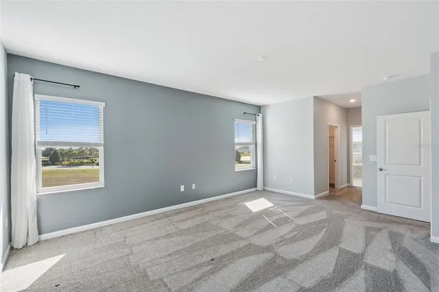 a view of an empty room with window and closet area