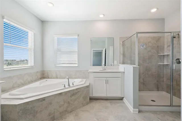 a spacious bathroom with a shower sink and mirror