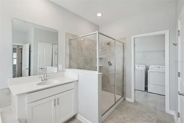 a bathroom with a shower sink and mirror