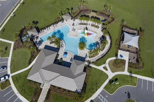 an aerial view of a house with a garden and lake view