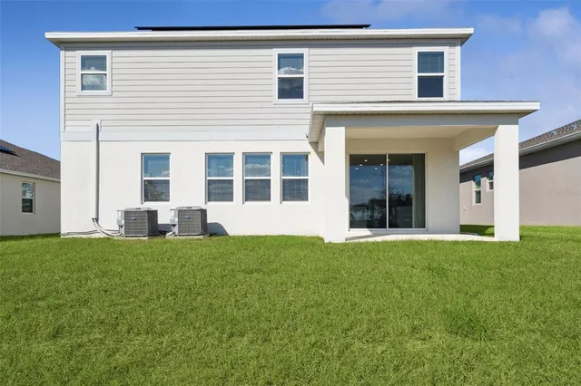 a white building with a big yard and more windows