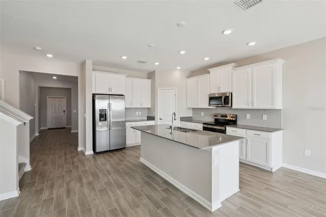 a kitchen with white cabinets and stainless steel appliances