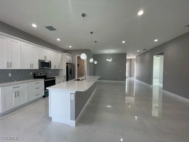 a kitchen with granite countertop a refrigerator and a stove top oven