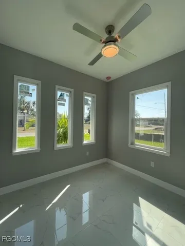an empty room with a window and a ceiling fan