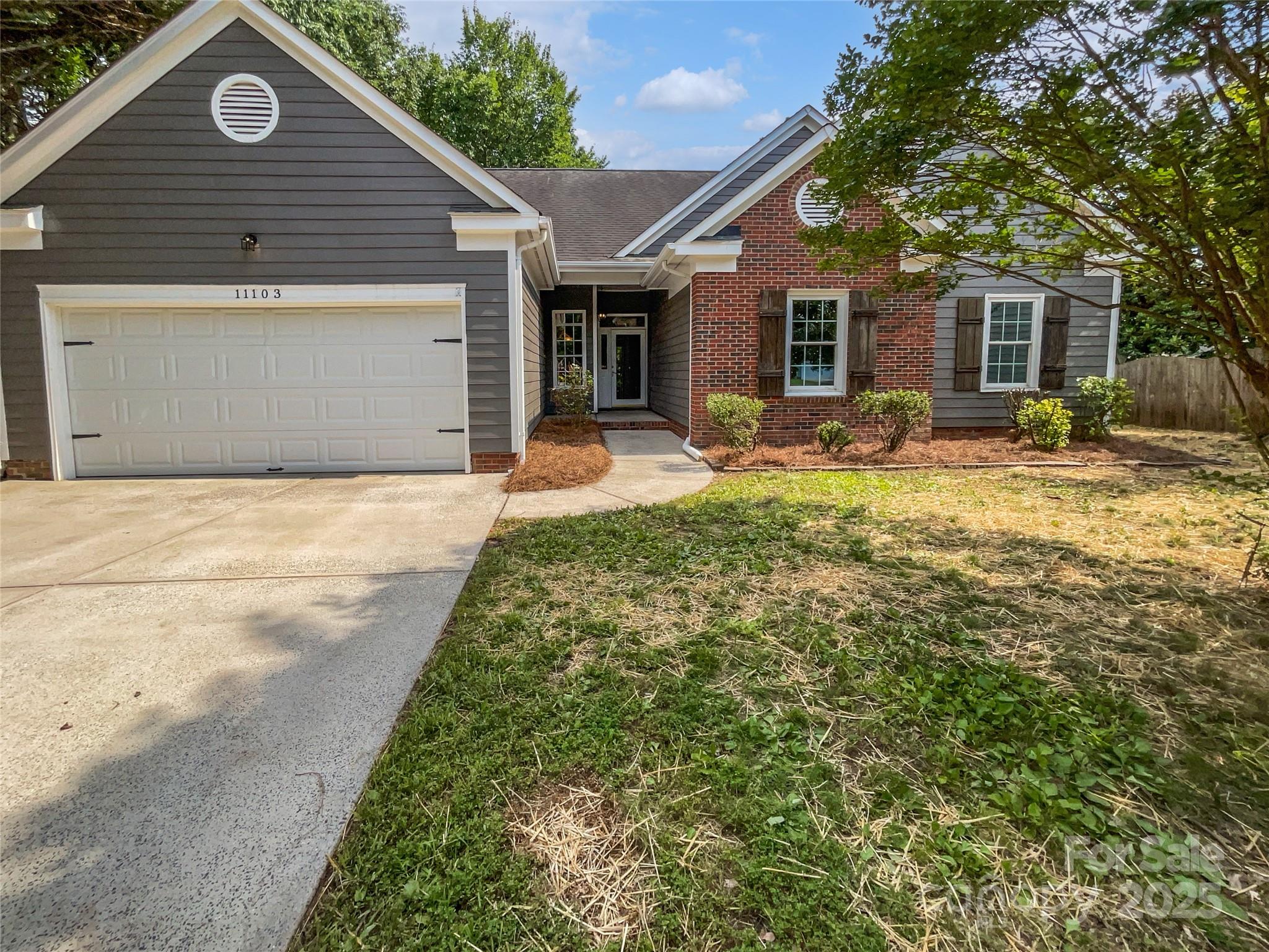 a front view of a house with yard and green space