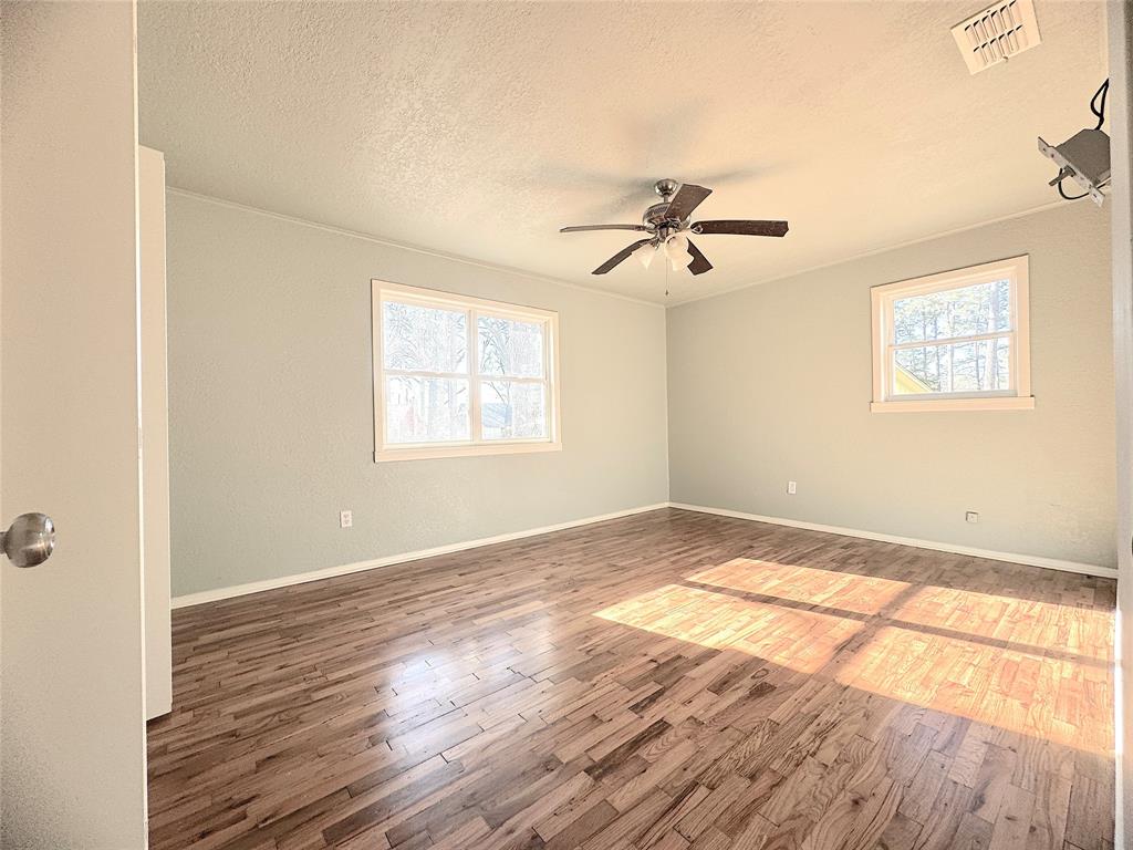 281 Lake Drive Mount Vernon, TX 75457 - Photo 6 of 13 an empty room with wooden floor and windows