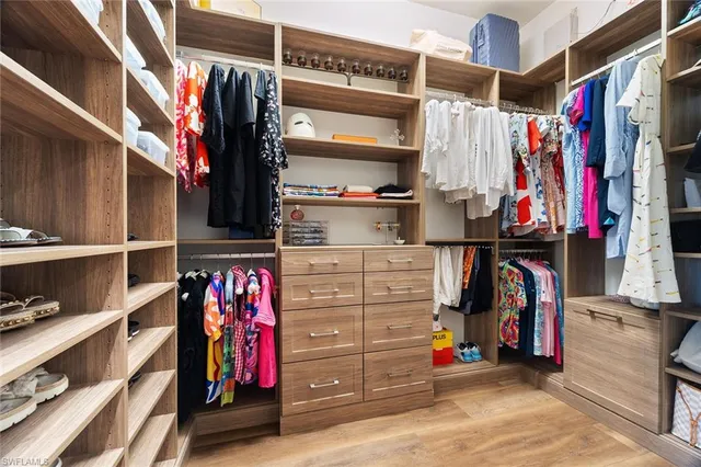a view of walk in closet with clothes and shoes