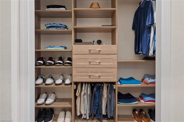 a view of walk in closet with clothes and shoes