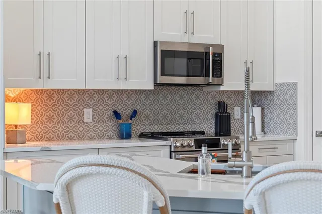 a kitchen with stainless steel appliances a stove a sink a microwave and cabinets