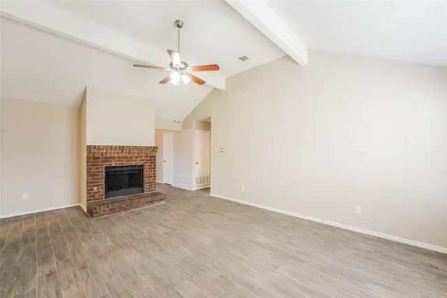 an empty room with a fireplace and fan