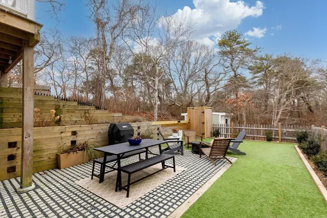 a view of a house with backyard and furniture