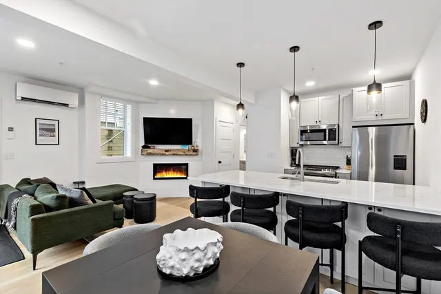 a living room with furniture kitchen view and a flat screen tv