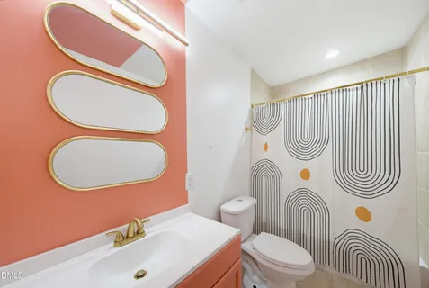 a bathroom with a sink a toilet mirror and vanity