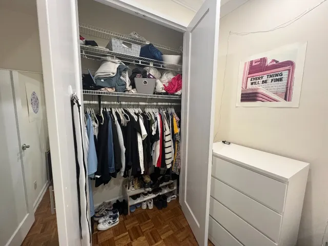 a view of walk in closet with clothes and shoes