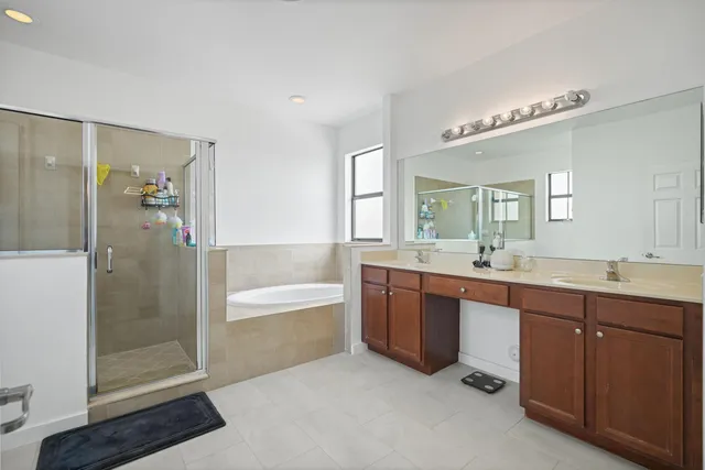 a spacious bathroom with a bathtub shower sink mirror and toilet