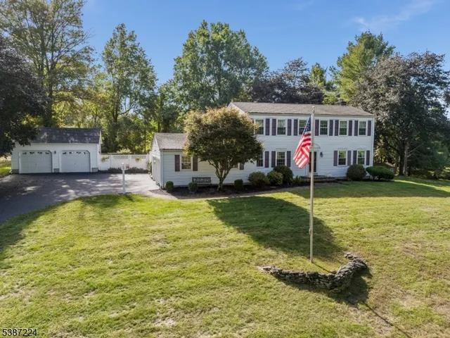 a view of house with swimming pool and a yard