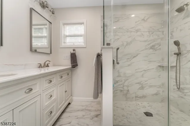 a bathroom with a double vanity sink a mirror and a shower