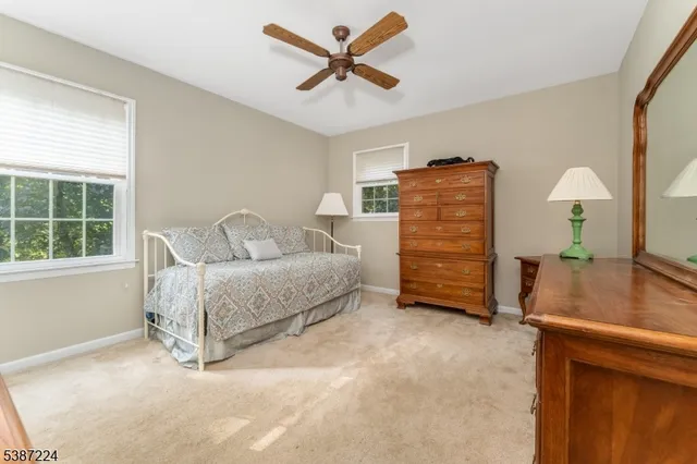 a bedroom with a bed a dresser and a window