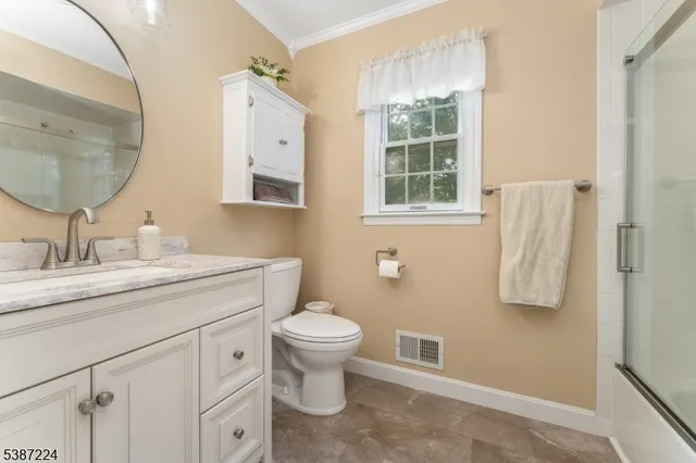 a bathroom with a granite countertop toilet sink and mirror