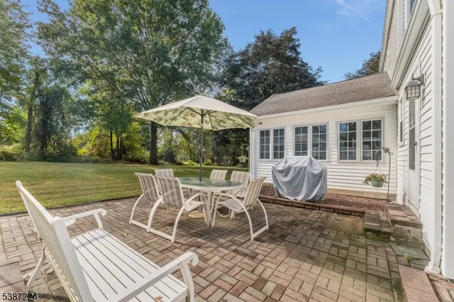 a view of a chair and table in the patio in front of a house