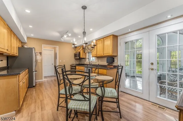 a view of a dining room with furniture a chandelier and wooden floor