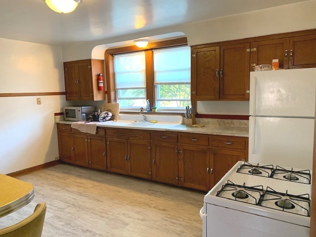 10931 South Artesian Avenue, Unit 2F Chicago, IL 60655 - Photo 5 of 11 a kitchen with a sink a stove and refrigerator