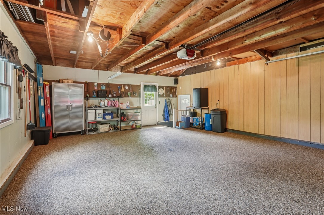 6130 Warren - Sharon Road Brookfield, OH 44403 - Photo 34 of 50 Garage featuring natural light and nature stone flooring...storage shelves and cabinets do NOT convey, additional storage above in loft/attic area...