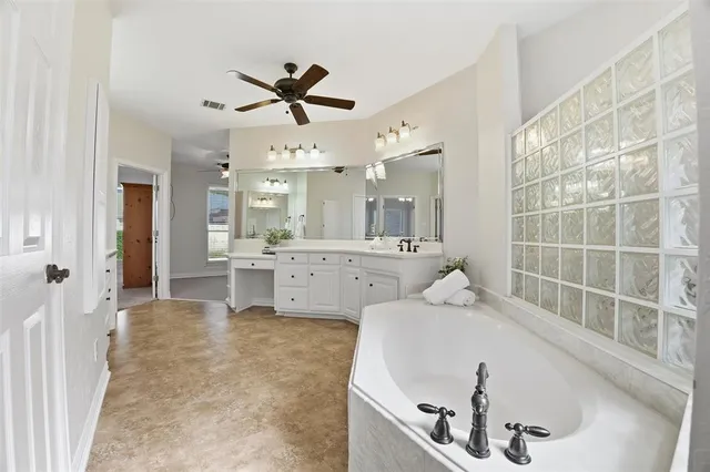 a en suite bathroom with a double vanity sink a mirror and a bathtub