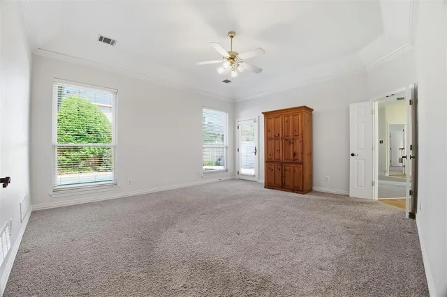 an empty room with fan and windows