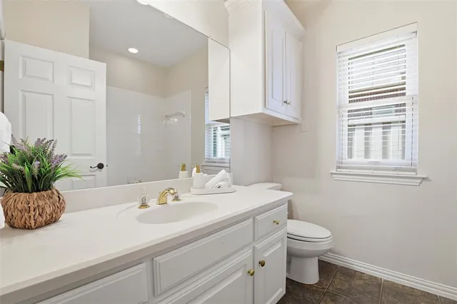 a bathroom with a sink a toilet and a window