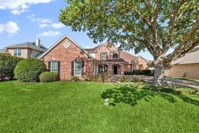 a front view of a house with a garden and trees