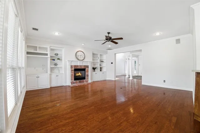 a view of empty room with wooden floor and fireplace