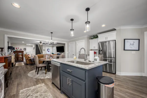 a kitchen with a sink stove and wooden floor
