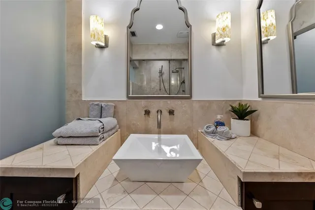 a bedroom with a large bed a chandelier and windows