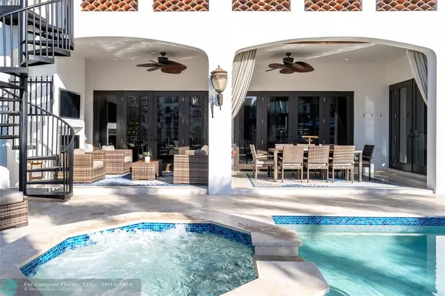 a view of a white house with swimming pool lawn chairs and a yard