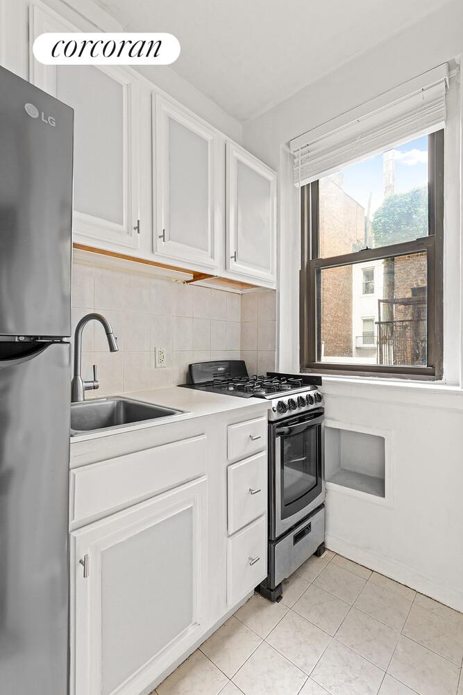 345 East 77th Street, Unit 3F Manhattan, NY 10075 - Photo 3 of 5 a kitchen with white cabinets and white appliances