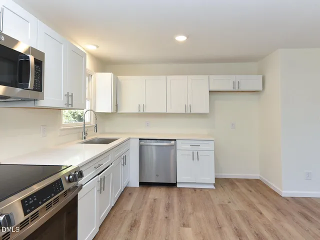 a kitchen with a sink stove top oven and cabinets