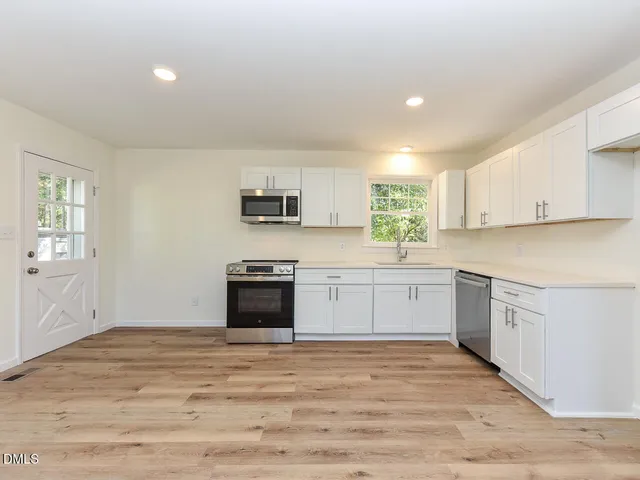 a kitchen with a refrigerator and a stove top oven