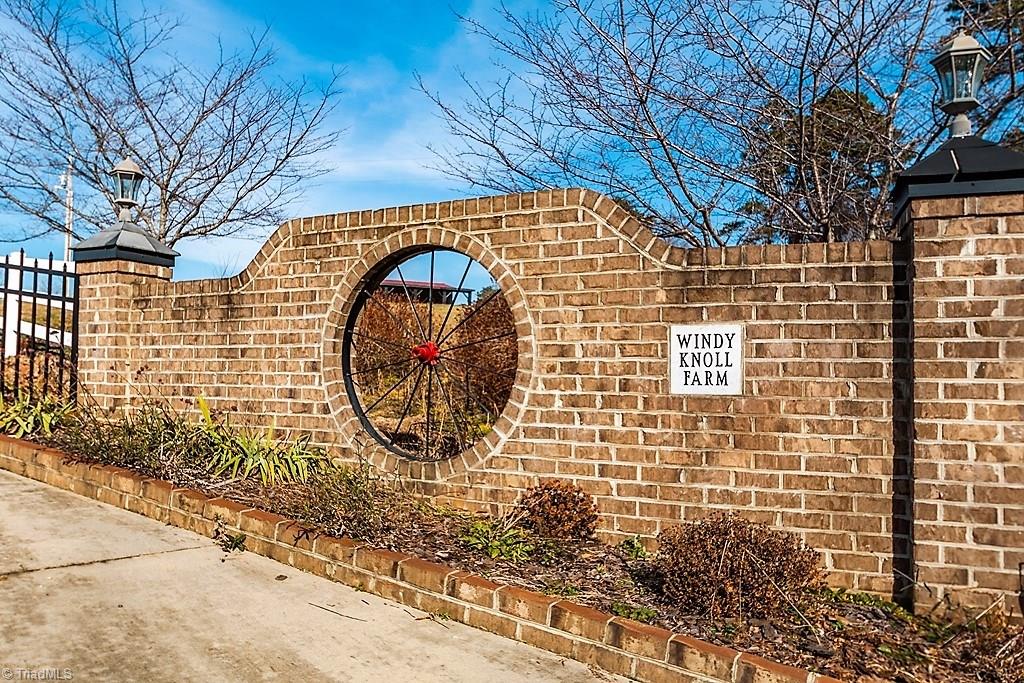 8315 Dennis Road Walnut Cove, NC 27052 - Photo 1 of 30 Wagon Wheel Encased Brick Walls invite you to this pristine horse/hobby farm. 6 stall barn, hay/equipment barn, brick ranch with full walk-out finished basement, vinyl fenced pastures, Koi pond & much more. Be sure to watch the video.
