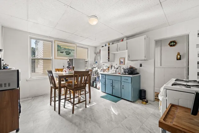 a kitchen with sink a table and chairs in it